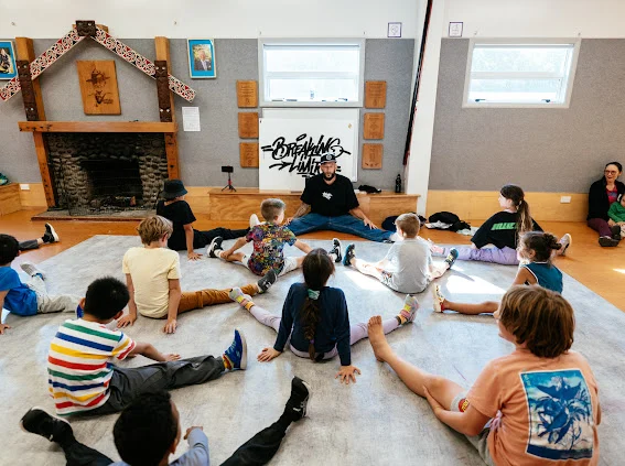Beginners class sitting in a circle on the floor at Ngaio Scout Hall
